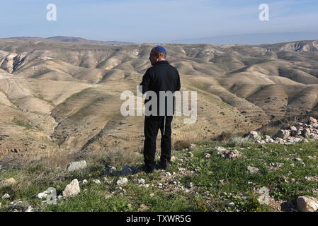 Un israeliano l'uomo guarda il panorama del Wadi Kelt dal Nofei Prat insediamento ebraico in Cisgiordania, 1 febbraio 2016. Nofei Prat è uno degli insediamenti israeliani che offre stanze in affitto ai turisti internazionali sull'home la condivisione e il noleggio del sito AirBNB. L' Autorità palestinese e i membri della BDS, Boicottare Israele movimento dire offering vacation rentals in case ebraiche nei territori occupati della Cisgiordania viola il diritto internazionale. Foto di Debbie Hill/ UPI Foto Stock