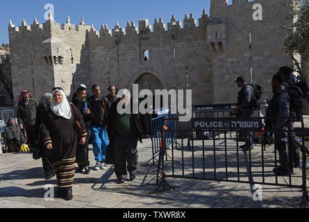 Palestinesi a piedi passato israeliano di polizia di frontiera al di fuori porta di Damasco diverse ore dopo un palestinese è stato ucciso dopo aver accoltellato due forze di polizia di confine presso Porta di Damasco a Gerusalemme est, 19 febbraio 2016. Il pugnalare attacco era il 11th. attacco terroristico alla porta di Damasco negli ultimi cinque mesi. Foto di Debbie Hill/ UPI Foto Stock