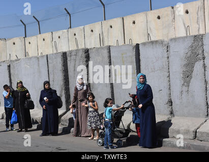 Palestinesi in stand by le barriere in calcestruzzo di fronte alla separazione israeliano parete al Checkpoint di Qalandiya, West Bank, Agosto 4, 2016. Palestinesi nel nord della Cisgiordania devono avere permessi per attraversare il Checkpoint di Qalandiya per raggiungere Gerusalemme. Foto di Debbie Hill/ UPI Foto Stock