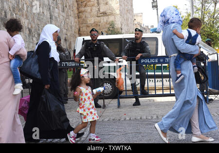 Palestinesi a piedi passato israeliano di polizia di frontiera in guardia al di fuori della città vecchia a Gerusalemme est, 22 settembre 2016. Soldati israeliani arrestati 23 palestinesi inizio Giovedì di incursioni nei diversi Gerusalemme Est i quartieri in una ricerca di armi e di persone sospette nella nuova ondata di pugnalare gli attacchi terroristici. La difesa Israeliano stabilimento si aspetta un aumento di attacchi in vista dei prossimi alta ebraico i giorni santi nei primi giorni di ottobre. Foto di Debbie Hill/ UPI Foto Stock