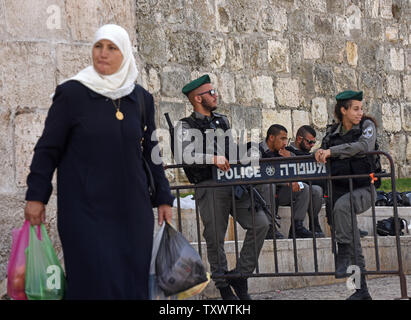 Un palestinese passa israeliano di polizia di frontiera in guardia al di fuori della città vecchia a Gerusalemme est, 22 settembre 2016. Soldati israeliani arrestati 23 palestinesi inizio Giovedì di incursioni nei diversi Gerusalemme Est i quartieri in una ricerca di armi e di persone sospette nella nuova ondata di pugnalare gli attacchi terroristici. La difesa Israeliano stabilimento si aspetta un aumento di attacchi in vista dei prossimi alta ebraico i giorni santi nei primi giorni di ottobre. Foto di Debbie Hill/ UPI Foto Stock