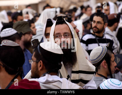 Un Ebreo Ultra-Orthodox l'uomo guarda libere le donne ebree, non visto, dal gruppo religioso delle donne della parete durante la preghiera del mattino il servizio presso il Muro Occidentale, ebraismo il santissimo sito, nella Città Vecchia di Gerusalemme, 27 febbraio 2017. La polizia israeliana Ultra-Orthodox separati uomini e delle donne ebree che protestavano donne liberali indossano tefillin, preghiera scialli e yarmulkes, ebraica oggetti religiosi che sono tradizionalmente solo indossato da uomini. Il controllo del Muro occidentale da Ultra-Orthodox ebrei è diventata un punto di conflitto tra la riforma e gli ebrei conservatori in America e la Isra Foto Stock