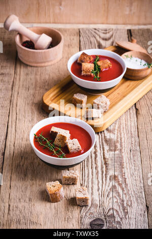 Tradizionale zuppa di pomodoro guarnita con pane di segale crostini e timo, impianto basato cibo, vicino il fuoco selettivo Foto Stock