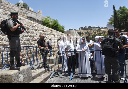 Frontiera israeliana controllo di polizia delle carte di identità dei palestinesi in attesa di accedere alla Città Vecchia di Gerusalemme attraverso la Porta del Leone nei pressi del Monte del Tempio, chiamato anche nobile santuario dai musulmani, 16 luglio 2017. La sicurezza di Israele ha riaperto il Monte del Tempio dopo l'installazione di misure di sicurezza aggiuntive, inclusi i rivelatori di metallo e macchine fotografiche, dopo che la Santa Sede è stata chiusa in quanto tre arabi israeliani uccisi due israeliani gli ufficiali di polizia in un attacco di scatto il venerdì. I capi del Jerusalem Islamic Waqf ha rifiutato di inserire il santo sito attraverso il popolo israeliano i rivelatori di metallo e ha organizzato una preghiera fuori il MOS Foto Stock