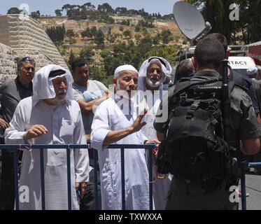 Frontiera israeliana controllo di polizia delle carte di identità dei palestinesi in attesa di accedere alla Città Vecchia di Gerusalemme attraverso la Porta del Leone nei pressi del Monte del Tempio, chiamato anche nobile santuario dai musulmani, 16 luglio 2017. La sicurezza di Israele ha riaperto il Monte del Tempio dopo l'installazione di misure di sicurezza aggiuntive, inclusi i rivelatori di metallo e macchine fotografiche, dopo che la Santa Sede è stata chiusa in quanto tre arabi israeliani uccisi due israeliani gli ufficiali di polizia in un attacco di scatto il venerdì. I capi del Jerusalem Islamic Waqf ha rifiutato di inserire il santo sito attraverso il popolo israeliano i rivelatori di metallo e ha organizzato una preghiera fuori il MOS Foto Stock