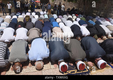 I musulmani palestinesi pregare al di fuori del Monte del Tempio, chiamato anche santuario nobile da musulmani, nei pressi della Porta del Leone in Gerusalemme la città vecchia, per protestare contro il nuovo israeliano misure di sicurezza, 16 luglio 2017. La sicurezza di Israele ha riaperto il Monte del Tempio dopo l'installazione di misure di sicurezza aggiuntive, inclusi i rivelatori di metallo e macchine fotografiche, dopo che la Santa Sede è stata chiusa in quanto tre arabi israeliani uccisi due israeliani gli ufficiali di polizia in un attacco di scatto il venerdì. I capi del Jerusalem Islamic Waqf ha rifiutato di inserire il santo sito attraverso israeliano i rivelatori di metallo e ha organizzato una preghiera al di fuori del cancello. - Foto Foto Stock