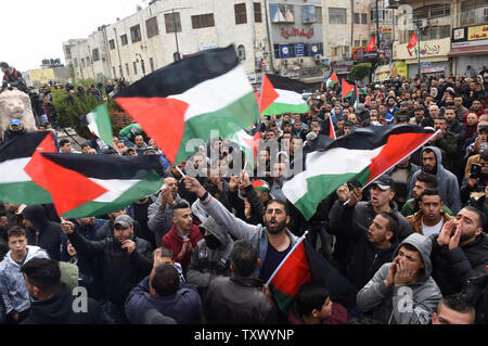 Palestinesi wave bandiere nazionali e per il canto di slogan durante una manifestazione di protesta contro la U.S. Presidente Donald Trump il riconoscimento di Gerusalemme come capitale di Israele a una manifestazione a Ramallah in Cisgiordania, 7 dicembre 2017. Foto di Debbie Hill/UPI Foto Stock