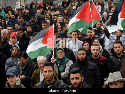 Palestinesi wave bandiere nazionali e per il canto di slogan durante una manifestazione di protesta contro la U.S. Presidente Donald Trump il riconoscimento di Gerusalemme come capitale di Israele a una manifestazione a Ramallah in Cisgiordania, 7 dicembre 2017. Foto di Debbie Hill/UPI Foto Stock