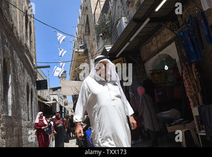 Passeggiata palestinese sotto bandiere israeliane nel Quartiere Musulmano nella Città Vecchia di Gerusalemme, 15 luglio, 2018. La Knesset israeliano è impostato a votare questa settimana sulla controversa legge Nation-State, che dovrebbe dare priorità ebraico oltre i valori democratici. La legge ultranationalist permetterebbe a Israele di costituire comunità che sono separati dalla religione o nazionalità. Il Primo Ministro israeliano Benjamin Netanyahu sta spingendo per la legge di passare, mentre American leader ebrei e israeliani moderati dicono che è un "razzista e discriminatoria' bill. Foto di Debbie Hill/UPI Foto Stock