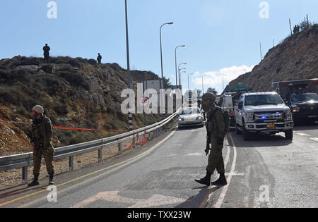 Soldati israeliani vicino la strada presso il sito dove un pistolero palestinesi uccisi due soldati israeliani e gravemente feriti due ulteriori, in un'unità da sparare a una fermata dell'autobus fuori dell'Givat Assaf avamposto, vicino a Ramallah in Cisgiordania, Dicembre 13, 2018. Il pistolero sbarcò il suo veicolo, ha aperto il fuoco e sono fuggiti dalla scena. L'esercito israeliano ha messo una chiusura a Ramallah e sta cercando per il tiratore. Foto di Debbie Hill /UPI Foto Stock