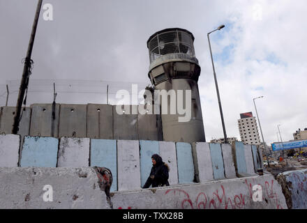 Un palestinese passeggiate barriere del passato al Checkpoint di Qalandiya, tra Gerusalemme e Ramallah, in Cisgiordania, 17 gennaio 2019. La televisione israeliana News ha riferito ieri che gli Stati Uniti Presidente Donald Trump la pace in Medio Oriente sarà piano includono sostituzioni territoriale nella maggior parte dei territorio della Cisgiordania e un campidoglio palestinesi a Gerusalemme Est. Foto di Debbie Hill/UPI Foto Stock