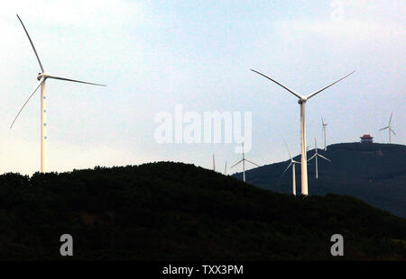 Le turbine eoliche spin e di generare potenza sulle creste delle colline in Fujin, una città di frontiera in Cina settentrionale della provincia di Heilongjiang il 3 agosto 2013. Cerca per regnare in sua conseguente aumento delle emissioni di gas a effetto serra, la Cina è un ambizioso spendendo spree in potere di vento. La Cina vanta il più grande del mondo la capacità di energia eolica e predice il paese della potenza eolica boom per battere l'energia nucleare entro il 2020. UPI/Stephen rasoio Foto Stock