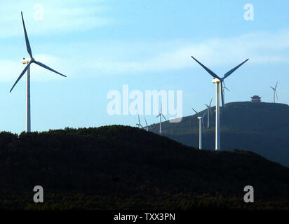 Le turbine eoliche spin e di generare potenza sulle creste delle colline in Fujin, una città di frontiera in Cina settentrionale della provincia di Heilongjiang il 3 agosto 2013. Cerca per regnare in sua conseguente aumento delle emissioni di gas a effetto serra, la Cina è un ambizioso spendendo spree in potere di vento. La Cina vanta il più grande del mondo la capacità di energia eolica e predice il paese della potenza eolica boom per battere l'energia nucleare entro il 2020. UPI/Stephen rasoio Foto Stock