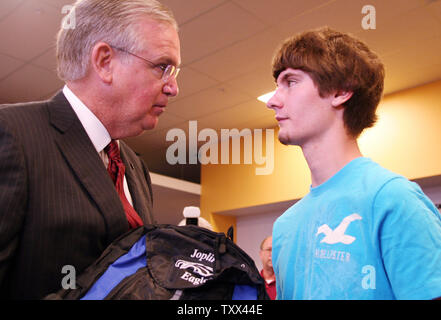 Mo. Gov. Jay Nixon mani il primo computer a senior Quinton Anderson sul giorno di apertura della scuola a Joplin, Missouri il 17 agosto 2011. Anderson, che è stato ferito criticamente nel maggio 22 tornado che ha ucciso 160 persone, ha perso entrambi i genitori nella tempesta. Computer portatili gratuiti sono stati distribuiti agli studenti a Joplin High School come parte di un 1 milione di dollari regalo da parte degli Emirati Arabi Uniti. UPI/Tom Uhlenbrock Foto Stock