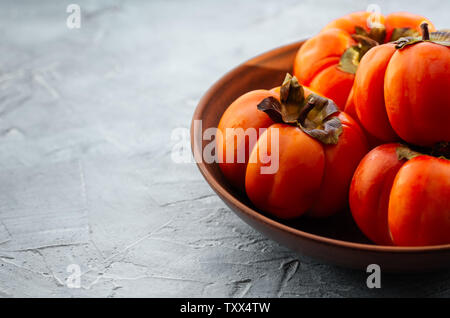 Arancione persimmon maturi frutti su uno sfondo luminoso. Sfondo con copia spazio, posto per testo, vista dall'alto Foto Stock