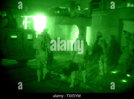 Elementi di Charlie Company 1-184th fanteria dell'esercito californiano Guardia nazionale, attaccato alla quarta brigata dell'3ID, il comportamento di un raid in una casa di insorti, a Baghdad, Iraq, 11 aprile 2005. Più di 500 le forze di sicurezza irachene, in cooperazione con la Task Force Baghdad soldati, cercato più di 90 obiettivi e 65 detenuti sospetti terroristi nel quartiere Al-Rasheed durante le incursioni inizio lunedì mattina a Baghdad. (UPI foto/Ken James) Foto Stock