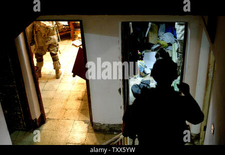 Elementi di Charlie Company 1-184th fanteria dell'esercito californiano Guardia nazionale, attaccato alla quarta brigata dell'3ID, il comportamento di un raid in una casa di insorti, a Baghdad, Iraq, 11 aprile 2005. Più di 500 le forze di sicurezza irachene, in cooperazione con la Task Force Baghdad soldati, cercato più di 90 obiettivi e 65 detenuti sospetti terroristi nel quartiere Al-Rasheed durante le incursioni inizio lunedì mattina a Baghdad. (UPI foto/Ken James) Foto Stock