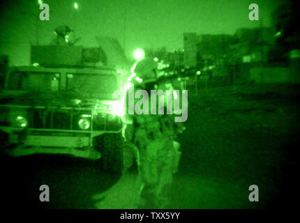 Elementi di Charlie Company 1-184th fanteria dell'esercito californiano Guardia nazionale, attaccato alla quarta brigata dell'3ID, il comportamento di un raid in una casa di insorti, a Baghdad, Iraq, 11 aprile 2005. Più di 500 le forze di sicurezza irachene, in cooperazione con la Task Force Baghdad soldati, cercato più di 90 obiettivi e 65 detenuti sospetti terroristi nel quartiere Al-Rasheed durante le incursioni inizio lunedì mattina a Baghdad. (UPI foto/Ken James) Foto Stock