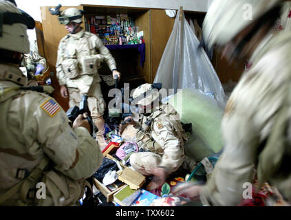 Elementi di Charlie Company 1-184th fanteria dell'esercito californiano Guardia nazionale, attaccato alla quarta brigata dell'3ID, il comportamento di un raid in una casa di insorti, a Baghdad, Iraq, 11 aprile 2005. Più di 500 le forze di sicurezza irachene, in cooperazione con la Task Force Baghdad soldati, cercato più di 90 obiettivi e 65 detenuti sospetti terroristi nel quartiere Al-Rasheed durante le incursioni inizio lunedì mattina a Baghdad. (UPI foto/Ken James) Foto Stock