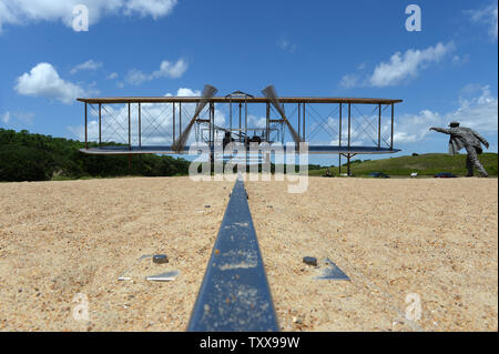 La rampa è in primo piano e Wilbur è a destra come la scultura denominata "dicembre 17, 1903' riproduce la scena del primo volo dei fratelli Wright a Wright Brothers National Memorial in uccidere diavolo sulle colline vicino a Kitty Hawk sul Outer Banks della Carolina del Nord il 25 luglio 2015. La scultura raffigurante Orville a bordo pesa 10.000 libbre, considerando che i fratelli Wright piano "Flyer 1' pesato 605 libbre. Il piano originale è presso lo Smithsonian di Washington DC. Orville e Wilbur Wright ha fatto le loro prove di parapendio dal 1900 e volò nel mondo il primo aereo su questo tratto di sabbia Foto Stock