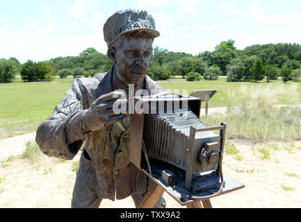 Una scultura denominata "dicembre 17, 1903' mostra John Daniels, chi ha preso la famosa foto, come esso si replica la scena del primo volo dei fratelli Wright a Wright Brothers National Memorial in uccidere diavolo sulle colline vicino a Kitty Hawk sul Outer Banks della Carolina del Nord il 25 luglio 2015. La scultura raffigurante Orville a bordo pesa 10.000 libbre, considerando che i fratelli Wright piano "Flyer 1' pesato 605 libbre. Il piano originale è presso lo Smithsonian di Washington DC. Orville e Wilbur Wright ha fatto le loro prove di parapendio dal 1900 e volò nel mondo il primo aereo su questo tratto di sandy beac Foto Stock