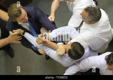 Legislatori ucraino dal regime comunista e a destra Svoboda (Libertà) partito lotta durante una sessione del Parlamento a Kiev il 23 luglio 2014. UPI/Ivan Vakolenko Foto Stock