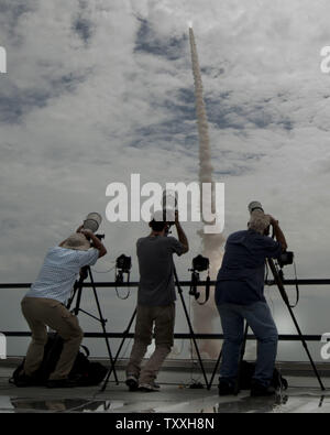 Dal tetto del gruppo del veicolo edificio, fotografi cattura il lancio della navetta spaziale "Atlantis' alle 11:29 Dal complesso 39a al Kennedy Space Center, Florida il 8 luglio 2011. Il lancio con un equipaggio di quattro per la Stazione Spaziale Internazionale, la Missione STS 135, è finale della NASA nella missione dello shuttle 30 anni di storia. Ora che la stazione per la costruzione è completa, Atlantis consegnerà le forniture e le attrezzature per essere utilizzato presso il complesso durante il post era navetta. Da questo punto in poi, la stazione sarà fornito da con o senza presidio russo razzi Soyuz. SpaceX è anche Foto Stock