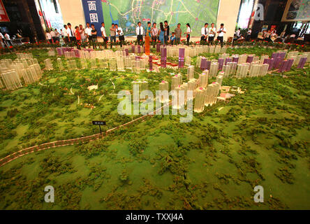 I potenziali proprietari guardare a un modello di un nuovo e imponente complesso urbano, uno dei più grandi sotto-costruzione in Cina, essendo costruito di Guiyang, la capitale della provincia di Guizhou sulla luglio 22, 2013. Nazionale Cinese consulenti politici della scorsa settimana ha messo in guardia circa i rischi di sacrificare la qualità di urbanizzazione per la velocità. Come lo scorso anno circa il 52 per cento della popolazione cinese vive in aree urbane, fino dal 20 percento circa trent'anni fa. Lo stesso processo ha preso la Gran Bretagna circa cento anni gli Stati Uniti 60 anni e Francia 65 anni. UPI/Stephen rasoio Foto Stock
