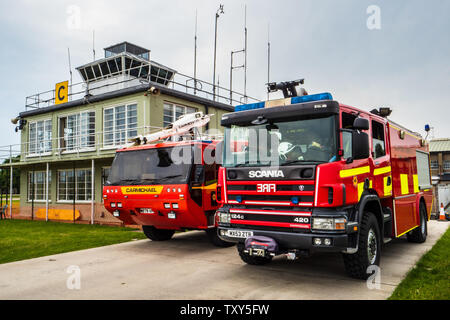 Aviosuperficie di servizio antincendio - Motori Fire presso il Museo Imperiale della Guerra airfield vicino a Cambridge Regno Unito, WW2 vintage della torre di controllo in background Foto Stock
