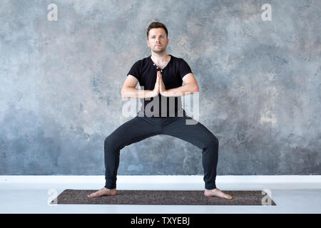 Uomo che lavora fuori, yoga, pilates, fitness training, dea porre o rudrasana Foto Stock
