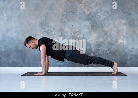 Sport giovani caucasici uomo facendo pieno doga. Foto Stock
