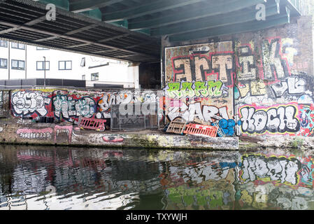 Hackney, East London, England, Regno Unito - Aprile 2019: murales e graffiti sotto un ponte ferroviario lungo il Regent's Canal vicino a Broadway Market, East London Foto Stock