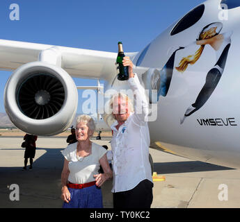 Virgin Group del miliardario fondatore Richard Branson contiene una bottiglia di champagne come egli battezza Virgin Galactic's mothership WhiteKnightTwo, Eve, in onore di sua madre Eva Branson (L) durante il suo pubblico di roll-out in Mojave, la California il 28 luglio 2008. Il twin fusoliera aeromobile White Knight due porterà astronave due per il lancio di passeggeri commerciali nello spazio. (UPI foto/Jim Ruymen) Foto Stock