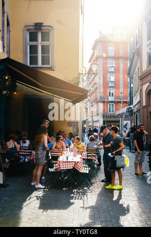 Strasburgo, Francia - 22 Luglio 2017: grande gruppo di persone in un ristorante esterno bar terrazza su 6 Rue du Vieux Seigle mangiare presso L'Epicerie con la luce del sole di svasatura angolo destro Foto Stock