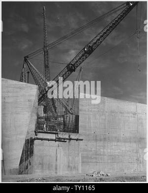 Vista da est in corrispondenza di estremità di valle di stramazzo che mostra una porzione incompleta di destra il canale sfioratore parete. La rigida-leg derricks mostrati sono dotati di 110 piedi di gru usate nella costruzione di stramazzo. Progetto fiume di Los Angeles il miglioramento. Ubicazione Hansen diga attraverso Tujunga Washington. Fondi di fondi regolari. Il lavoro perseguita sotto contratto n. W-509-Eng.689. Foto Stock