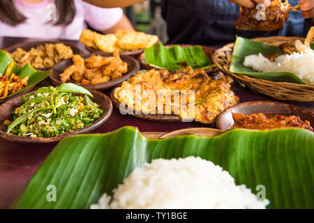 Dall'aspetto gustoso cibo indonesiano servita al tavolo con una varietà di salse, riso, gamberi e pollo frittata di e. Viaggi e cibo Concetto di immagine fro Foto Stock