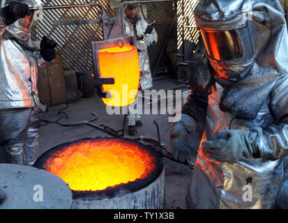 I lavoratori di fire adatta per preparare a versare in bronzo fuso di metallo in stampi durante la colata del premio di cooperativa di attori di schermo statuette, all'American Fine Arts Foundry on gennaio 21, 2011 di Burbank, in California. La premiazione che si terrà a Los Angeles il 30 gennaio. UPI/Jim Ruymen Foto Stock