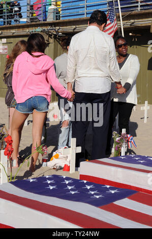 Un gruppo di persone tenere le mani in preghiera presso l'Arlington West Memorial Progetto in Santa Monica, in California, il 29 maggio 2011. Il 12 mock scrigni sono accanto a rappresentare i soldati uccisi questa settimana: 10 in Afghanistan e 2 in Iraq. UPI /Jim Ruymen) Foto Stock