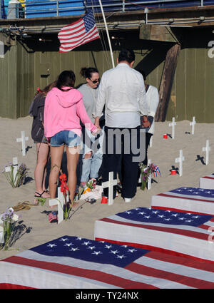 Un gruppo di persone tenere le mani in preghiera presso l'Arlington West Memorial Progetto in Santa Monica, in California, il 29 maggio 2011. Il 12 mock scrigni sono accanto a rappresentare i soldati uccisi questa settimana: 10 in Afghanistan e 2 in Iraq. UPI /Jim Ruymen) Foto Stock