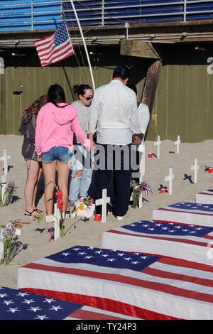 Un gruppo di persone tenere le mani in preghiera presso l'Arlington West Memorial Progetto in Santa Monica, in California, il 29 maggio 2011. Il 12 mock scrigni sono accanto a rappresentare i soldati uccisi questa settimana: 10 in Afghanistan e 2 in Iraq. UPI /Jim Ruymen) Foto Stock