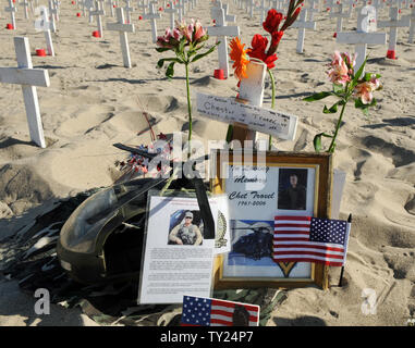 Fiori, fotografie di Capt. Chester Troxel, e un modello di elicottero Blackhawk sono nella foto accanto a una croce come parte di un Giorno Memoriale della visualizzazione all'Arlington West Memorial Progetto in Santa Monica, in California, il 29 maggio 2011. Troxel è stato ucciso quando il suo Blackhawk si è schiantato all inizio della guerra in Iraq. Il beach memorial rappresenta il 4,454 soldati uccisi in Iraq e 2,393 uccisi in Afghanistan. Il 12 mock scrigni rappresentano i soldati uccisi questa settimana: 10 in Afghanistan e 2 in Iraq. UPI /Jim Ruymen) Foto Stock