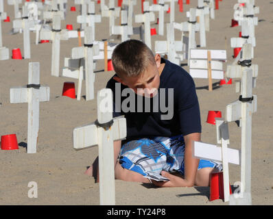 Mica Butler riflette come egli siede tra croci sullo schermo di Arlington West Memorial Progetto in Santa Monica, in California, il 29 Maggio 2011.Le migliaia di croci presso il beach memorial rappresenta il 4,454 soldati uccisi in Iraq e 2,393 uccisi in Afghanistan. Il 12 mock scrigni rappresentano i soldati uccisi questa settimana: 10 in Afghanistan e 2 in Iraq. A destra è Robert Uranga. UPI /Jim Ruymen) Foto Stock