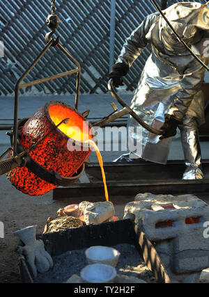 I lavoratori di fire adatta a versare in bronzo fuso di metallo in stampi durante la colata del premio di cooperativa di attori di schermo statuette, all'American Fine Arts Fonderia di Burbank, in California, il 19 gennaio 2012. La premiazione che si terrà a Los Angeles il 29 gennaio 2012. UPI/Jim Ruymen Foto Stock