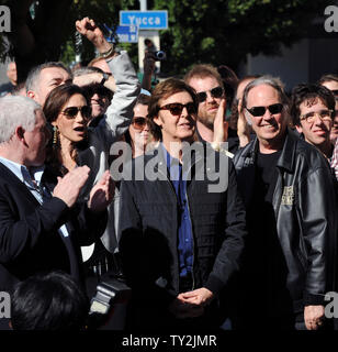 Ex Beatle Paul McCartney (C) e sua moglie Nancy Shevell (L) ascoltare commenti durante una cerimonia di inaugurazione in onore di McCartney con il 2,460th della stella sulla Hollywood Walk of Fame a Los Angeles il 9 febbraio 2012. Guardando a destra è musicista Neil Young. UPI/Jim Ruymen Foto Stock