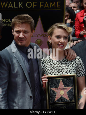 L'attrice Scarlett Johansson detiene una placca di replica come lei pone con l'attore Jeremy Renner durante una cerimonia di inaugurazione venerandola con il 2,470th della stella sulla Hollywood Walk of Fame a Los Angeles il 2 maggio 2012. UPI/Jim Ruymen Foto Stock