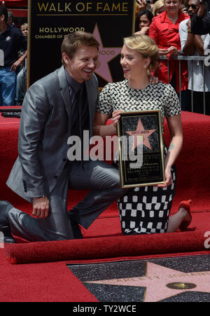 L'attrice Scarlett Johansson detiene una placca di replica come lei pone con l'attore Jeremy Renner durante una cerimonia di inaugurazione venerandola con il 2,470th della stella sulla Hollywood Walk of Fame a Los Angeles il 2 maggio 2012. UPI/Jim Ruymen Foto Stock