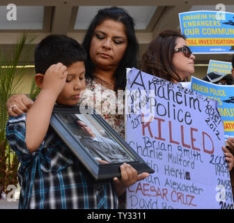 Jose Morales detiene una foto di Marcel Ceja, deceduto dopo una polizia-coinvolte le riprese, come egli si unisce a un gruppo di attivisti fuori Attorney General Kamala Harris' ufficio a Los Angeles il 30 luglio 2012, sollecitando il suo.indagare la polizia di Anaheim negli ultimi officer coinvolti tiri. UPI/Jim Ruymen Foto Stock