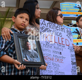 Jose Morales detiene una foto di Marcel Ceja, deceduto dopo una polizia-coinvolte le riprese, come egli si unisce a un gruppo di attivisti fuori Attorney General Kamala Harris' ufficio a Los Angeles il 30 luglio 2012, sollecitando il suo.indagare la polizia di Anaheim negli ultimi officer coinvolti tiri. UPI/Jim Ruymen Foto Stock