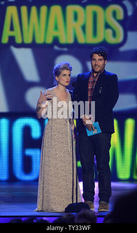 Personalità televisiva Kelly Osbourne (L) e l'attore Adam Pally presente un premio sul palco durante il fare qualcosa di premi al Barker Hangar di Santa Monica, in California, il 19 agosto 2012. UPI/Jim Ruymen Foto Stock