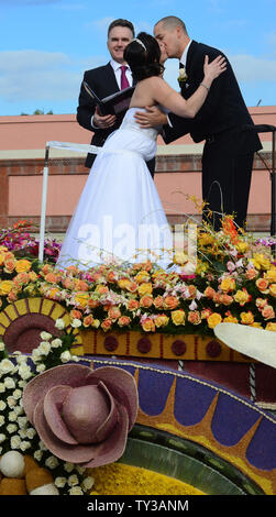 Gerald Sapienza e Nicole Angelillo di Chesapeake, Virginia, kiss dopo essere stata dichiarata l'uomo e la moglie in una speciale Rose Parade cerimonia. Agli sposi novelli battere tre altre coppie in lizza per sposarsi a bordo gli agricoltori InsuranceÕs òla amore FloatÓ, come essi partecipano al torneo 124di Rose Parade tenutasi a Pasadena, in California il 1 gennaio 2013. UPI/Jim Ruymen Foto Stock